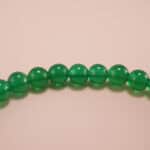 Close-up of green chalcedony bracelet with smooth finish.