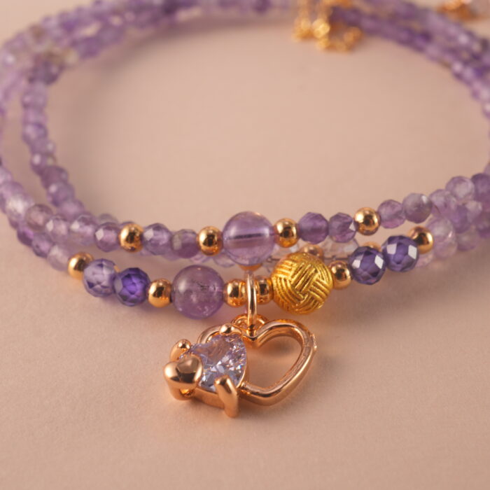 Close-up of polished amethyst beads and clasp detail, revealing the gemstone’s natural clarity and craftsmanship.
