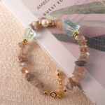 Full view of the bracelet featuring skeleton quartz textures, paired with smooth pearl and aquamarine tones.