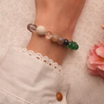 Model wearing a handmade bracelet featuring lava stone, green agate, and clear quartz – natural and earthy on the wrist.