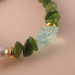 Close-up of jade, pearl, and aquamarine beads showing their natural textures and high-quality craftsmanship.