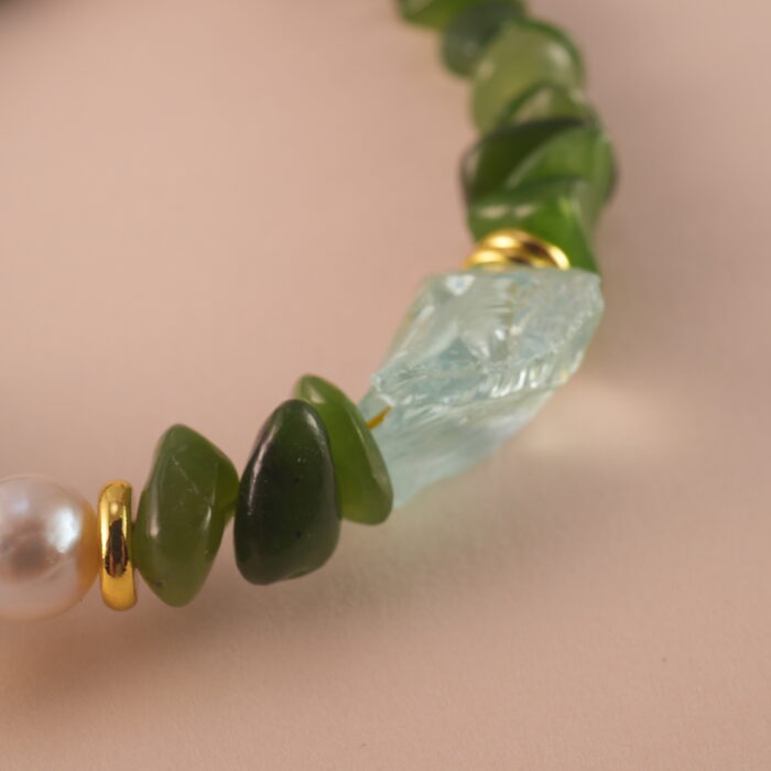 Close-up of jade, pearl, and aquamarine beads showing their natural textures and high-quality craftsmanship.