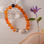 Detailed display of handmade bracelet featuring fiery carnelian, translucent quartz, and porous lava beads.