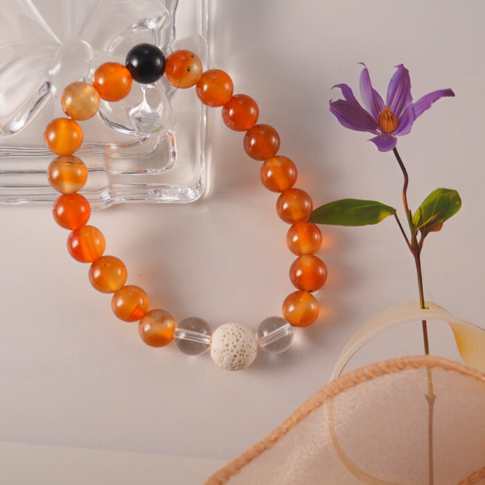 Detailed display of handmade bracelet featuring fiery carnelian, translucent quartz, and porous lava beads.