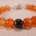 Close-up of bracelet texture showing the raw lava stones and polished carnelian and quartz beads.
