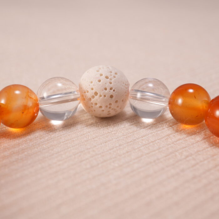 Close-up of bracelet texture showing the raw lava stones and polished carnelian and quartz beads.