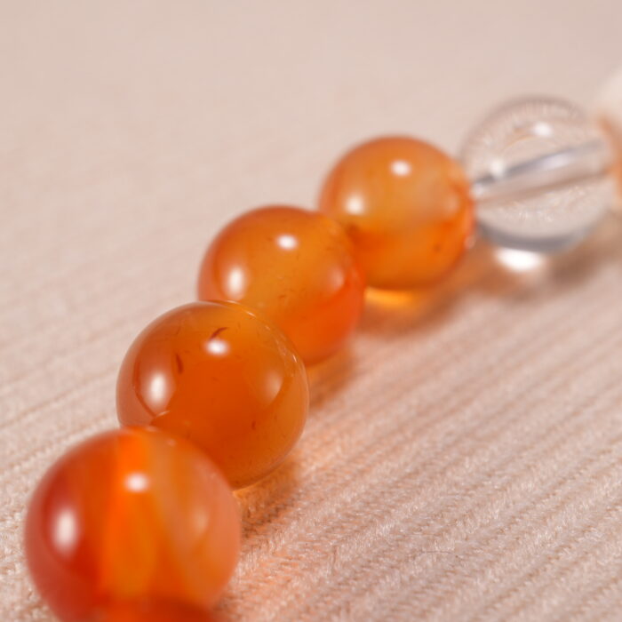 Close-up of bracelet texture showing the raw lava stones and polished carnelian and quartz beads.