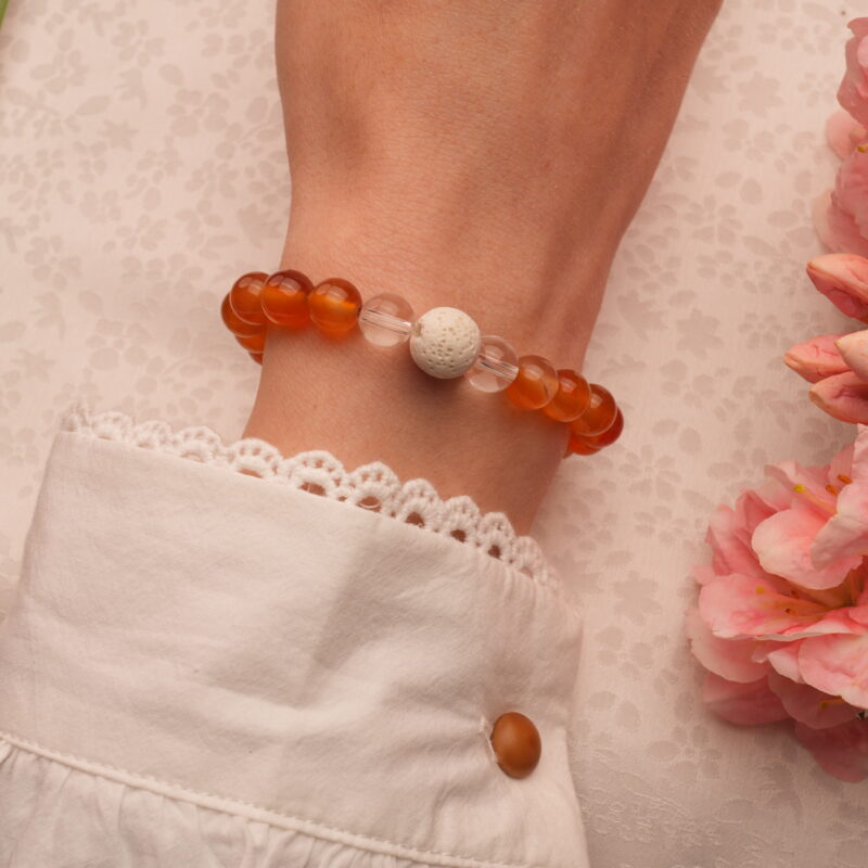 Wrist shot of a handmade carnelian and clear quartz bracelet with lava stones – earthy and vibrant on skin.