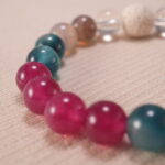 Close-up view showing texture of lava stone beads and polished surface of chalcedony, agate, and quartz.