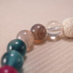 Close-up view showing texture of lava stone beads and polished surface of chalcedony, agate, and quartz.