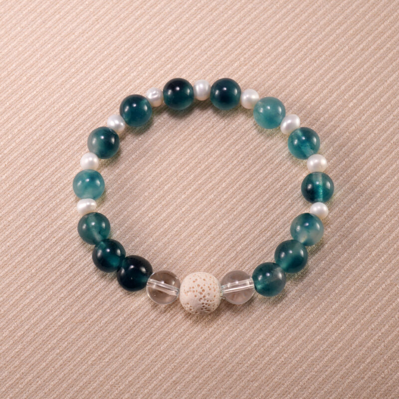 Handmade bracelet with lava stone, blue chalcedony, freshwater pearl, and clear quartz – elegant and soothing crystal piece.