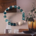 Detailed view of the bracelet showcasing textured lava stone, soft chalcedony, luminous pearl, and clear quartz beads.