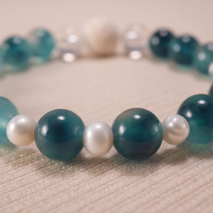 Close-up image highlighting the contrast between matte lava stone and smooth chalcedony, pearl, and quartz.