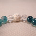 Close-up image highlighting the contrast between matte lava stone and smooth chalcedony, pearl, and quartz.