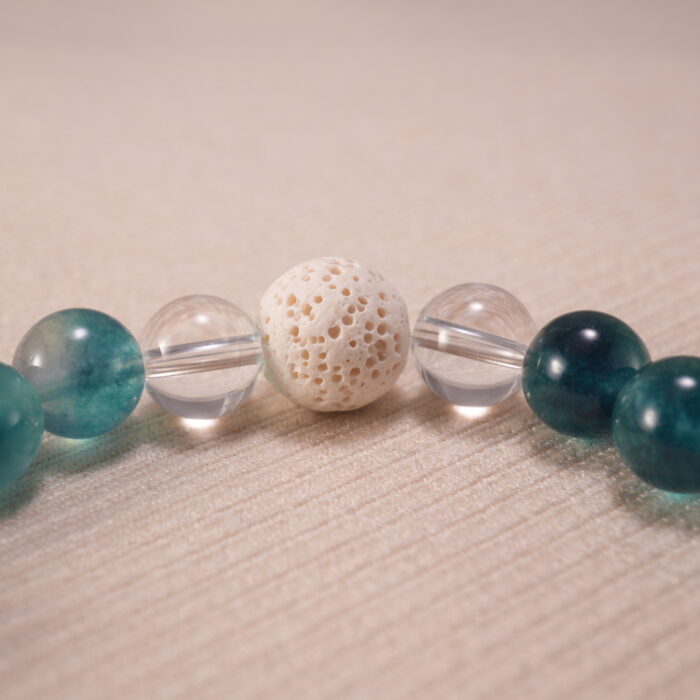 Close-up image highlighting the contrast between matte lava stone and smooth chalcedony, pearl, and quartz.