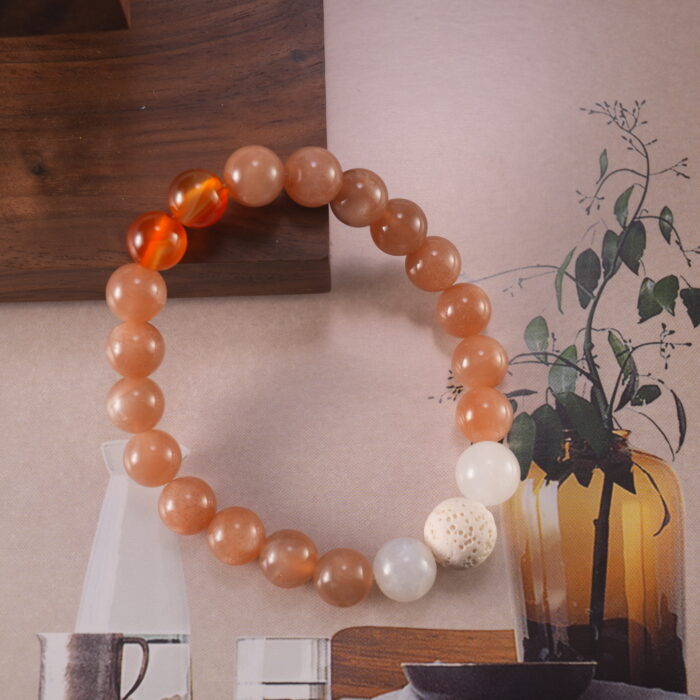 Close-up view showing carnelian, white chalcedony, and moonstone beads arranged in a harmonious color flow.