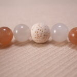 Detailed shot of porous lava stone contrasted with smooth, glossy gemstone textures.