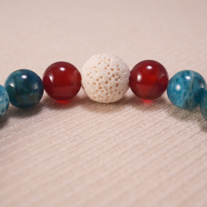 Macro shot showing the porous texture of Lava Stone and the translucent quality of Fluorite beads.