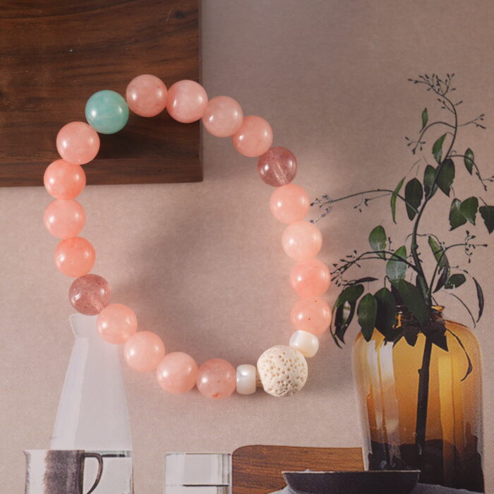 Detailed shot of the bracelet layout, showing the smooth rose chalcedony, shimmering strawberry quartz, and calming amazonite.