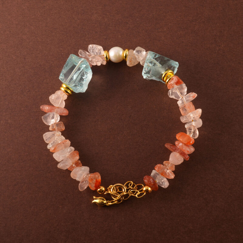 Handmade Leo zodiac bracelet featuring Fire Quartz, Pearl, and Aquamarine beads arranged in a minimalist design.