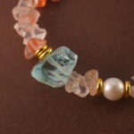 Close-up of the bracelet’s Fire Quartz bead, revealing rich reddish hues and subtle internal patterns.