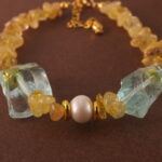 Close-up of golden rutilated quartz bead with visible golden inclusions and polished finish.