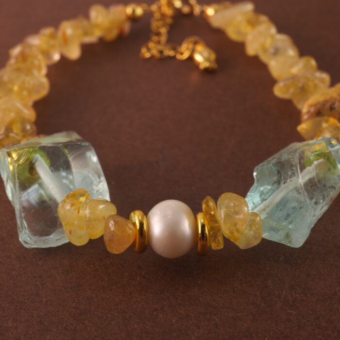 Close-up of golden rutilated quartz bead with visible golden inclusions and polished finish.