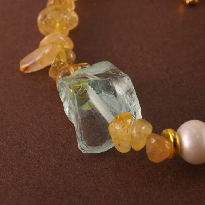 Close-up of golden rutilated quartz bead with visible golden inclusions and polished finish.