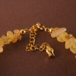 Close-up of golden rutilated quartz bead with visible golden inclusions and polished finish.