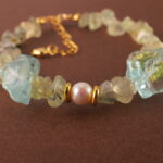 Close-up shot of the prehnite bead, revealing its soft green hue and natural internal textures.