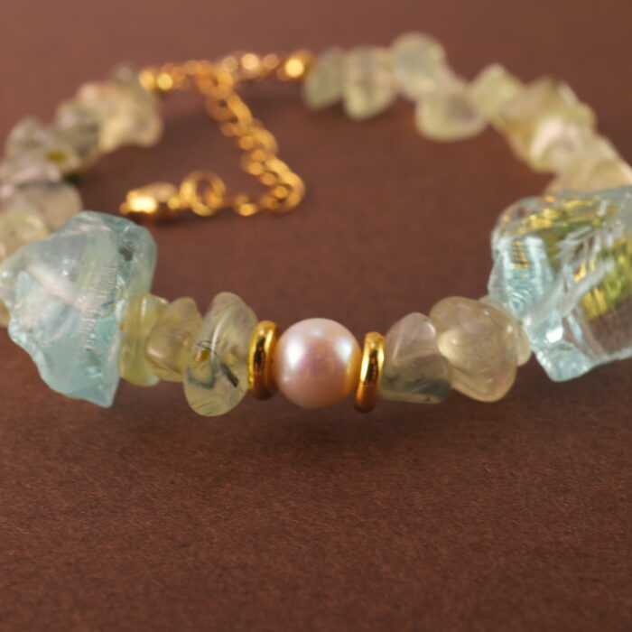 Close-up shot of the prehnite bead, revealing its soft green hue and natural internal textures.