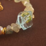 Close-up shot of the prehnite bead, revealing its soft green hue and natural internal textures.
