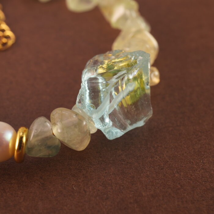 Close-up shot of the prehnite bead, revealing its soft green hue and natural internal textures.