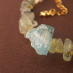 Close-up shot of the prehnite bead, revealing its soft green hue and natural internal textures.