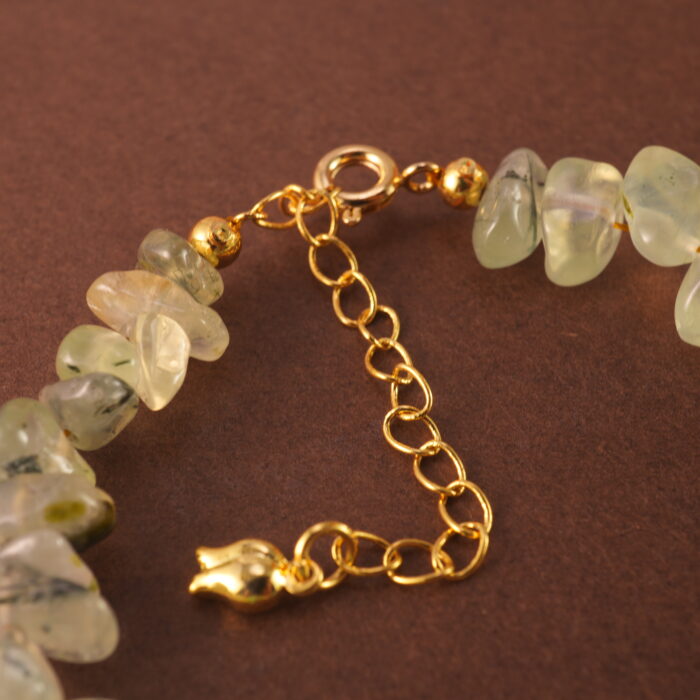 Close-up shot of the prehnite bead, revealing its soft green hue and natural internal textures.