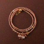 Handmade rose quartz necklace that can also be worn as a three-wrap bracelet, shown coiled elegantly.