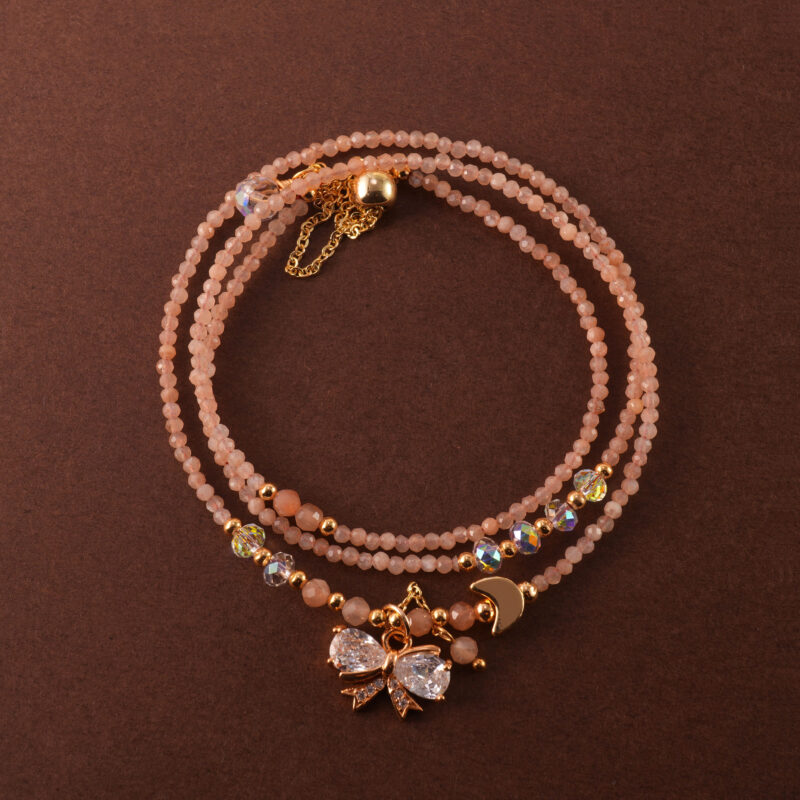 Handmade rose quartz necklace that can also be worn as a three-wrap bracelet, shown coiled elegantly.