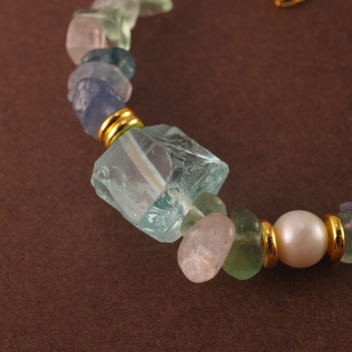 Detailed view of the Sagittarius bracelet highlighting the natural textures and subtle glow of fluorite, pearl, and aquamarine stones.