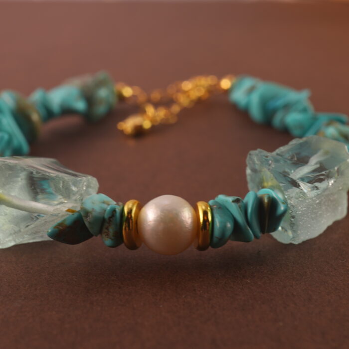 Close-up showing the texture and subtle luster of turquoise, pearl, and aquamarine beads.