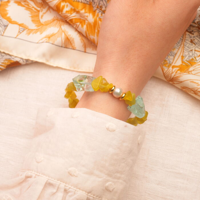 The Virgo bracelet worn on wrist, showcasing the soft green hues of peridot and the calming blues of aquamarine.