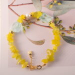 Close-up showing the natural textures and luster of peridot, aquamarine, and pearl beads.