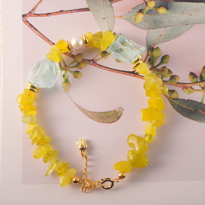 Close-up showing the natural textures and luster of peridot, aquamarine, and pearl beads.