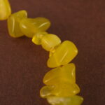 Close-up showing the natural textures and luster of peridot, aquamarine, and pearl beads.