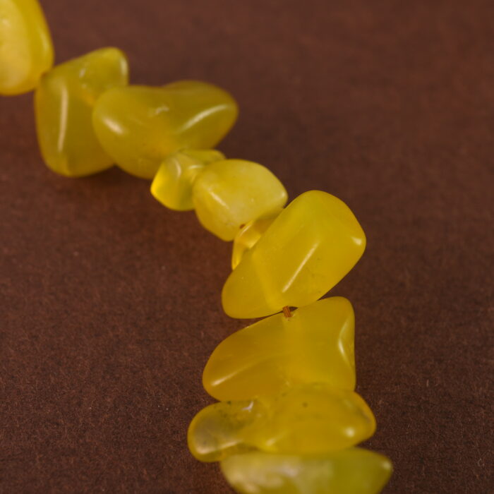 Close-up showing the natural textures and luster of peridot, aquamarine, and pearl beads.