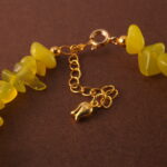 Close-up showing the natural textures and luster of peridot, aquamarine, and pearl beads.