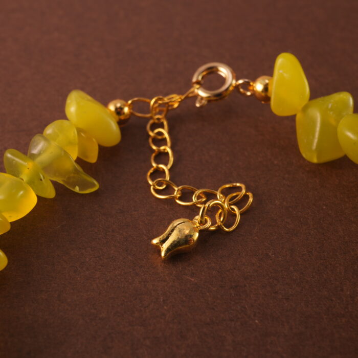 Close-up showing the natural textures and luster of peridot, aquamarine, and pearl beads.