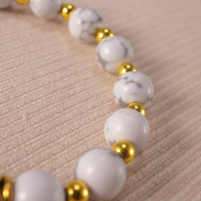 Close-up of howlite evil eye bracelet with matte white texture.