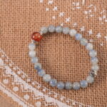 Bracelet in natural light with deep blue and rich red tones.