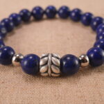 Close-up of lapis lazuli bracelet with S925 silver charm.