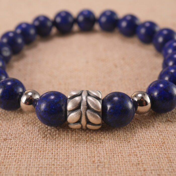 Close-up of lapis lazuli bracelet with S925 silver charm.